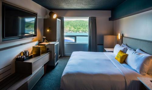 um quarto de hotel com uma cama grande e uma televisão em DoubleTree by Hilton St. John's Harbourview em St. John's