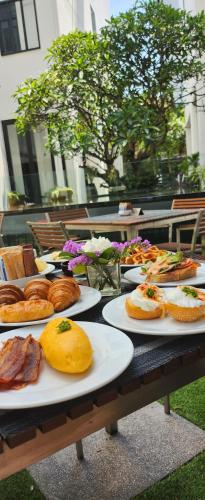 a table with plates of bread and pastries on it at Mövenpick Hotel Sukhumvit 15 Bangkok in Bangkok