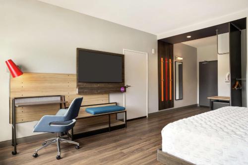 a hotel room with a bed and a desk and a tv at Tru By Hilton Longview in Longview