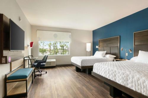 a hotel room with two beds and a desk at Tru By Hilton Longview in Longview