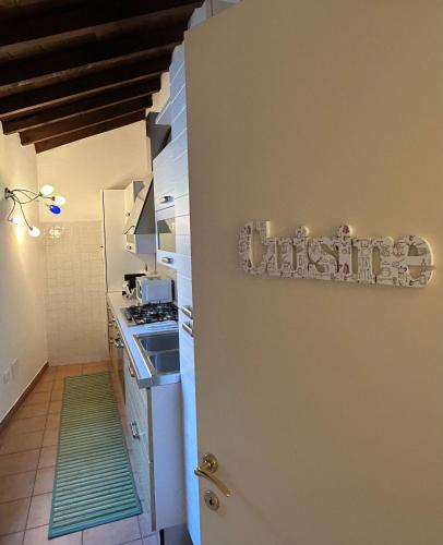 a kitchen with a sign that saysitz on the wall at Chez Madame in Ferrara