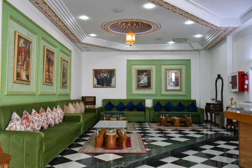 a living room with green furniture and a checkered floor at Hotel Annakhil in Nador