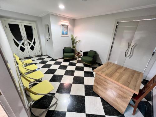 a waiting room with yellow chairs on a checkered floor at Hotel Annakhil in Nador