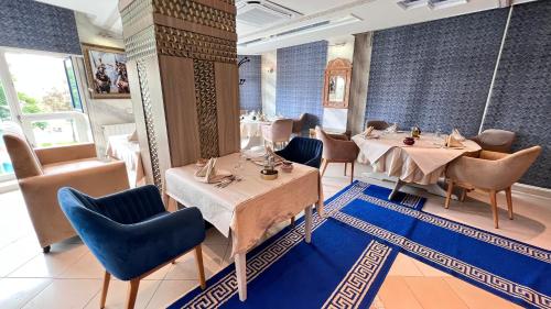 a dining room with two tables and chairs at Hotel Annakhil in Nador