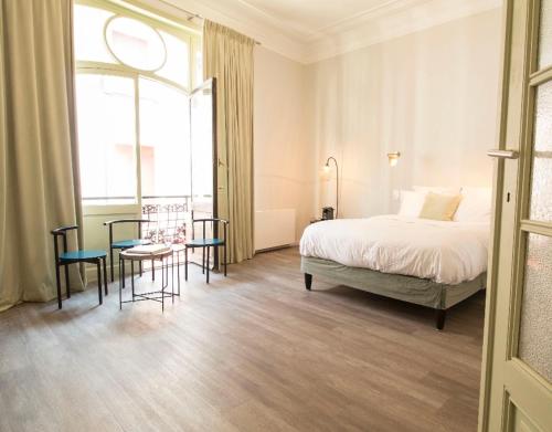 1 dormitorio con 1 cama, mesa y sillas en Wok Rooms en Bruselas