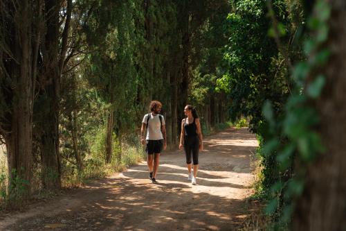 two people walking down a dirt road at I Cinque Pini in Follonica