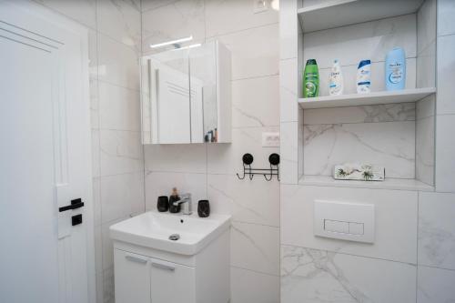 ein weißes Badezimmer mit einem Waschbecken und einem Spiegel in der Unterkunft Villa Zulfikar in Mostar