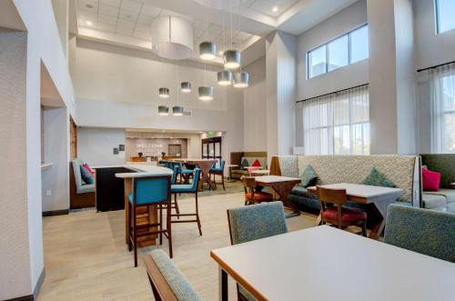 a lobby with tables and chairs and a cafeteria at Hampton Inn & Suites Portland West in Portland