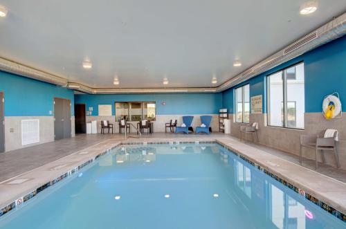 a swimming pool with chairs and tables in a building at Hampton Inn & Suites Portland West in Portland