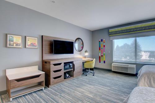 a hotel room with a bed and a desk with a television at Hampton Inn & Suites Portland West in Portland