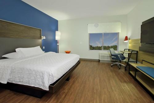 a hotel room with a bed and a desk and a television at Tru By Hilton Mobile in Mobile
