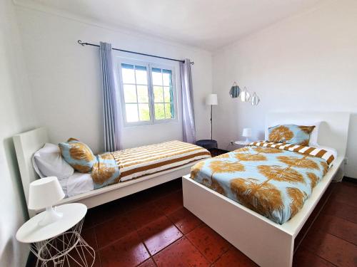 een slaapkamer met 2 bedden en een raam bij House Levada in Ponta Delgada