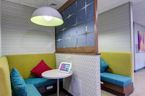 a waiting room with a table and a laptop at Hampton Inn & Suites Portland West in Portland