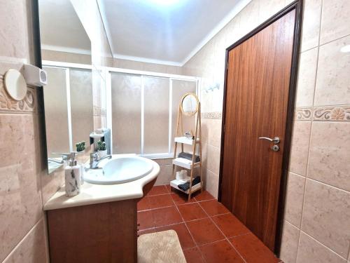 een badkamer met een wastafel en een spiegel bij House Levada in Ponta Delgada