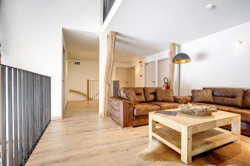 a living room with a couch and a table at Au Frêne in Houffalize