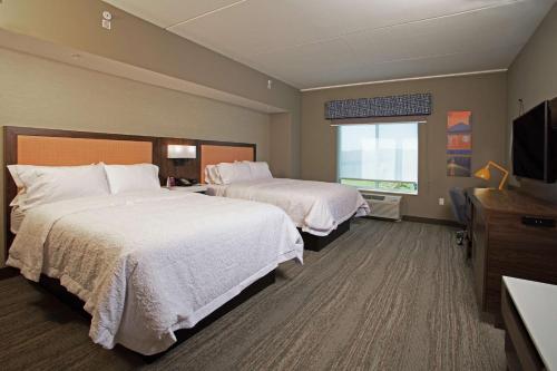 Kutztown的住宿－Hampton Inn & Suites Kutztown, Pa，酒店客房设有两张床和电视。