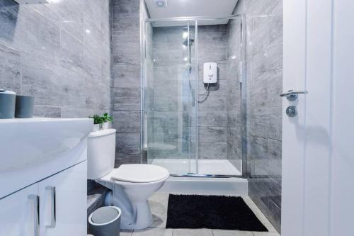 a bathroom with a shower and a toilet and a sink at Beautiful apartment tres - free public parking in Litherland