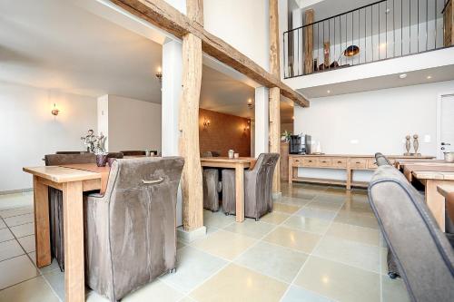 duża kuchnia z drewnianymi stołami i krzesłami w obiekcie Au Frêne w mieście Houffalize