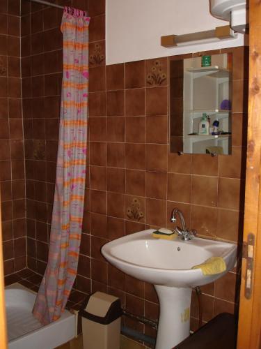 une salle de bain avec un lavabo et un rideau de douche dans l'établissement Maison Vacances Mer, à Bages
