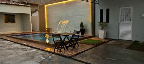 a patio with a table and a swimming pool at Casa jardim para temporada em Piranhas-Alagoas in Piranhas