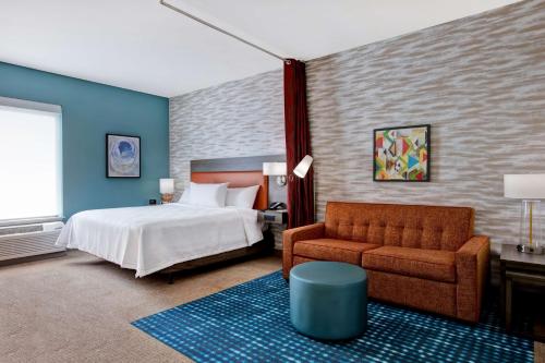 una camera d'albergo con letto e divano di Home2 Suites By Hilton Charlotte Northlake a Charlotte