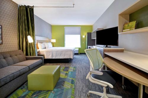 a hotel room with a bed and a desk at Home2 Suites By Hilton Taylor Detroit in Taylor