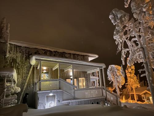 a house covered in snow at night at Pikkuhukka in Syöte