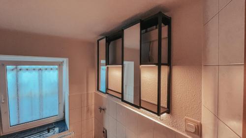 a bathroom with two mirrors and a window at Amalie's FeWo in Siebenlehn