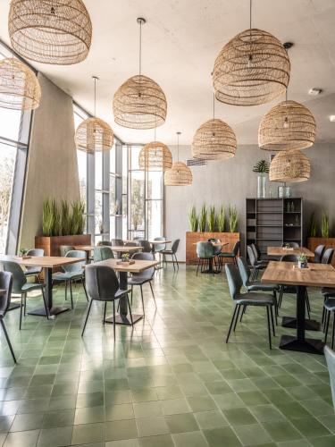 a restaurant with tables and chairs and large windows at Falkensteiner Premium Mobile Homes and Camping Zadar in Zadar