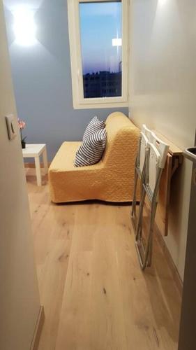 Cette chambre dispose d'un canapé, d'une fenêtre et de parquet. dans l'établissement La chambre de Léonie, à Toulon