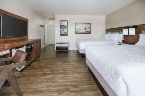 a hotel room with two beds and a flat screen tv at Hampton Inn Key West FL in Key West
