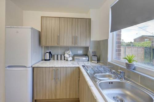 a kitchen with a sink and a white refrigerator at Sleek and Stylish 3 Bed House In Central Hull in Hull