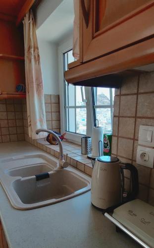 a kitchen counter with a sink and a window at The Fig Tree - Deluxe Studio in Ios Chora