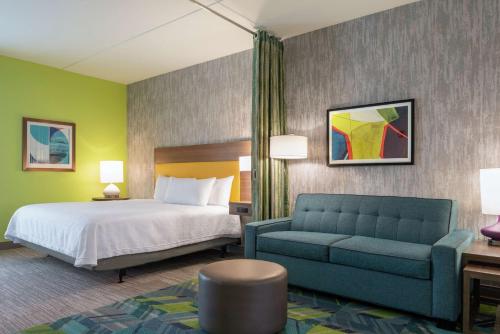 ein Hotelzimmer mit einem Bett und einem Sofa in der Unterkunft Home2 Suites By Hilton Dayton/Beavercreek, Oh in Beavercreek