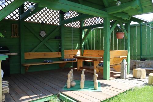 a wooden pergola with a bench and four bowling pins at Penzion-apartmán Souček in Jindrichuv Hradec