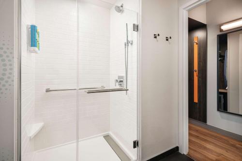 丹佛Tru By Hilton Denver Downtown Convention Center的浴室里有玻璃门的淋浴间