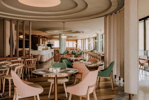 restauracja ze stołami i krzesłami oraz sufitem w obiekcie Hilton Swinoujscie Resort And Spa w Świnoujściu