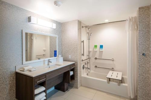 a bathroom with a sink and a tub and a mirror at Home2 Suites By Hilton Phoenix Airport North, Az in Phoenix