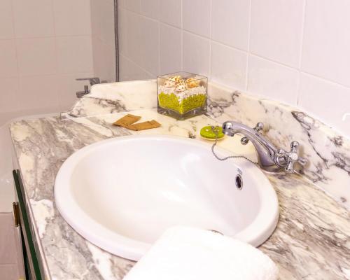 a bathroom sink with a white marble counter top at Mountain Getaway for Hikers 1 in Arafo