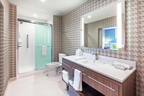 a bathroom with a sink and a toilet and a mirror at Home2 Suites By Hilton Abilene, TX in Abilene
