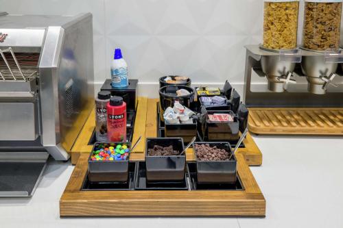 a display of food and drinks on a table next to a machine at Hilton Garden Inn Knoxville Papermill Drive, Tn in Knoxville