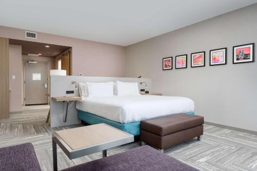 a hotel room with a large bed and a table at Hilton Garden Inn Knoxville Papermill Drive, Tn in Knoxville