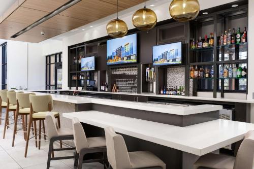 a bar in a restaurant with chairs and tables at Hilton Garden Inn Knoxville Papermill Drive, Tn in Knoxville