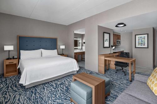 a hotel room with a bed and a desk at Homewood Suites by Hilton Boston Woburn in Woburn