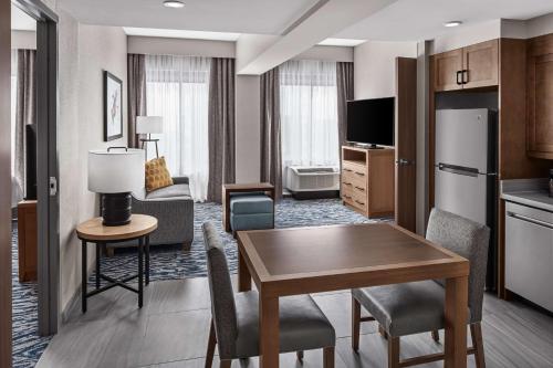 a hotel room with a kitchen and a dining room at Homewood Suites by Hilton Boston Woburn in Woburn