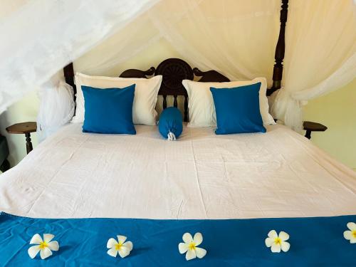 ein weißes Bett mit blauen und weißen Blumen darauf in der Unterkunft Museum Villa 09 in Beruwala