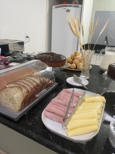 a table topped with different types of bread and pastries at Hospedagem Penha - Beto carreiro e Praias in Penha