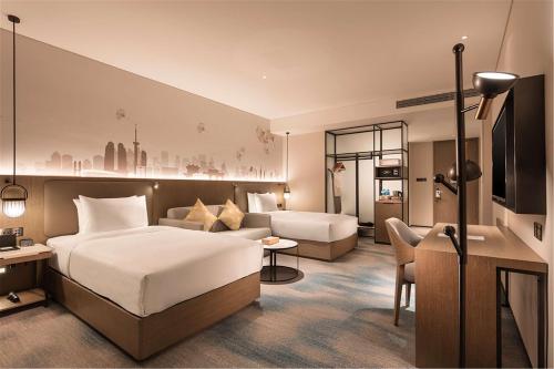 pokój hotelowy z łóżkiem i kanapą w obiekcie Hilton Garden Inn Xuzhou Yunlong w mieście Xuzhou