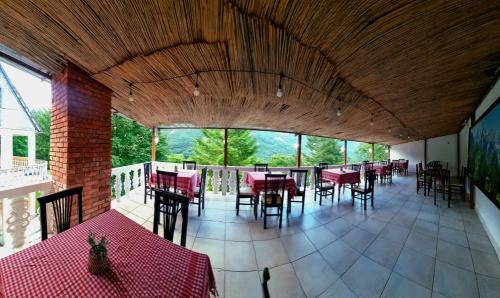 a dining room with tables and chairs and windows at Bujtina Te Grima in Theth