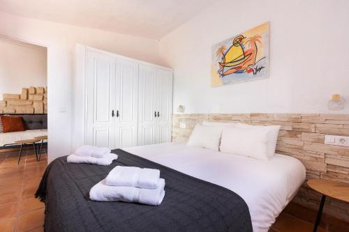 um quarto com uma grande cama branca com toalhas em Mountain Getaway for Hikers 2 em Arafo